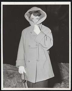 A Cold Look -- Betty O'Leary of Brighton has a warm smile despite her cold look as she crosses Boston Common in near zero weather, bundled up with a fur lined parka held close around her face.