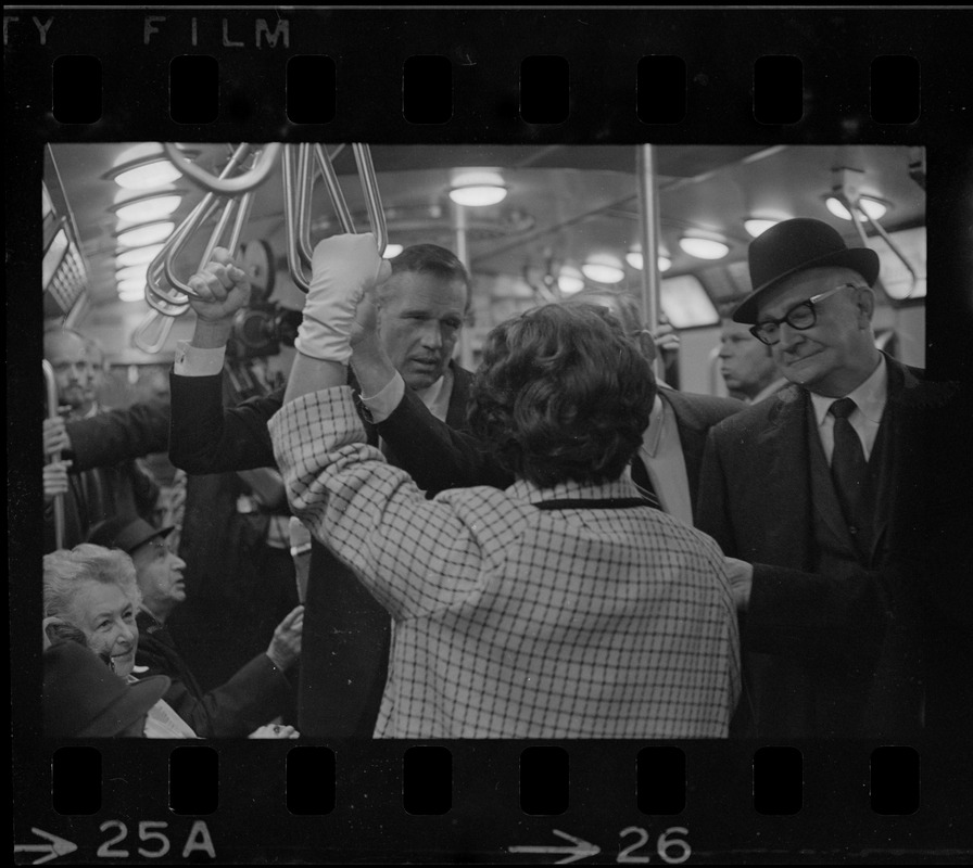 New MBTA Board Chairman, Dr. Robert C. Wood, with fellow commuter Gov. Sargent straphanging on train nearing Columbia Station