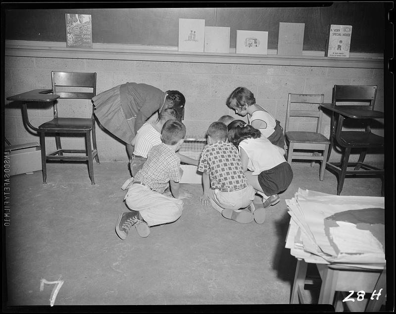 Children gathered around something on the floor - Digital Commonwealth