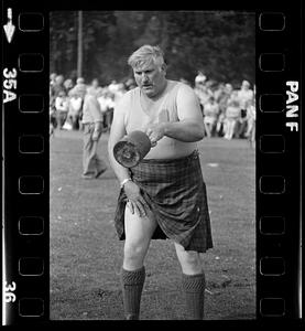 Man in kilt swings weight