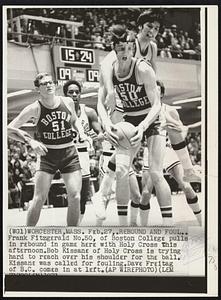 Rebound and Foul.. Frank Fitzgerald No.50, of Boston College pulls in rebound in game here with Holy Cross this afternoon. Bob Kissane of Holy Cross is trying hard to reach over his shoulder for the ball. Kissane was called for fouling. Dave Freitag of B.C. comes in at left.