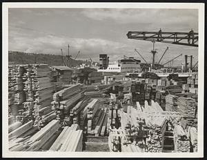 Lumber Business Again Booming in Great Northwest. Seattle, Washington -- With the Pacific Maritime Strike a thing of the past, many Seattle and Tacoma lumber yards are fairly bustling with activity. This industrial-scenic photograph shows the British Motor Ship, "Pacific Exporter" loading at the Western Waterway Docks with lumber of London.