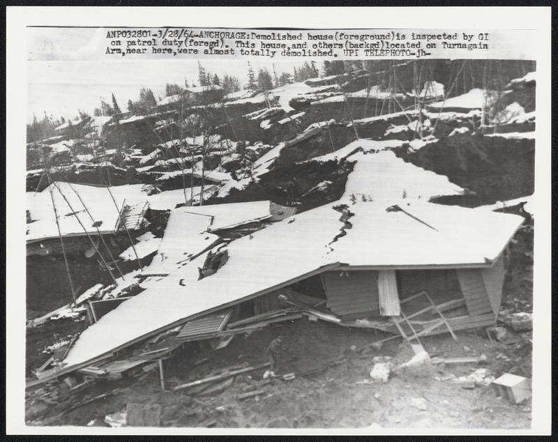 Anchorage: Demolished house (foreground) is inspected by GI on patrol duty (foregd). This house, and other (backgd) located on Turnagain Arm, near here, were almost totally demolished.