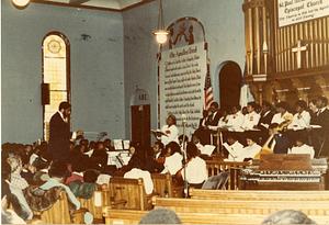 St. Paul AME's Messiah, chorus and orchestra with alto soloist Jaqueline Richardson standing, 1983