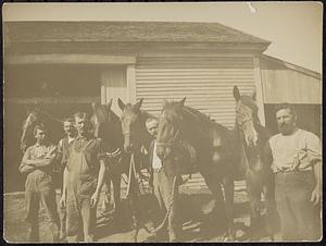 Five men with five horses in front of stable