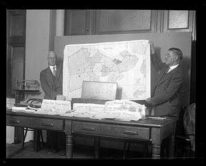 Two men holding up a map of Boston