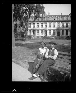 Two men sit on a park bench