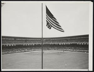 Flag at Half-Mast for Comiskey But Game Must go on. News of the death of J. Louis Comiskey, owner and president of the Chicago White Sox reached his team while they were engaged in the second game of a double-header with the Boston Red Sox and the flag in center field was immediately lowered to half staff; the game went on to completion. Mr. Comiskey, who was 54 years old, died of heart disease and pneumonia at his summer home in Eagle River, Wisc., Photo shows the center field flag at half-mast as the second game went on, at Comiskey Park.