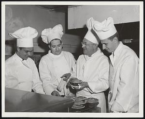 Hotel Statler Chefs Frank Medicina and Patsy Mazzuchelli, center left to right, give practical lessons in behind-the-scenes work to Jim Nassikas, far left, and Raymond LaForce, both of Manchester and students at the University of New Hampshire. The boys spent the whole day yesterday in the Statler kitchens.