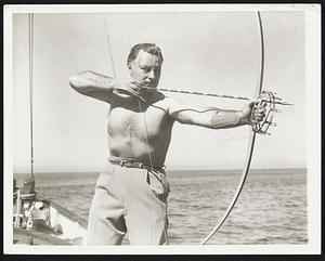Roy Maples, expert bow-and-arrow fisherman, takes careful aim at one of the many game fish at Santa Catalina. The shaft of the arrow is birch, 30 inches in length.