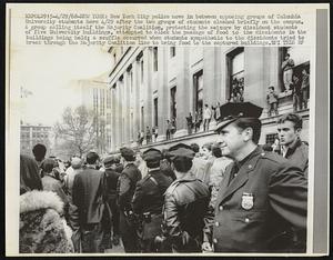New York City police move in between opposing groups of Columbia University students here 4/29 after the two groups of students clashed briefly on the campus. A group calling itself the Majority Coalition, protesting the seizure by dissident students of five University buildings, attempted to block the passage of food to the dissidents in the buildings being held; a scuffle occurred when students sympathetic to the dissidents tried to break through the Majority Coalition line to bring food to the captured buildings.