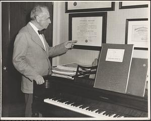 Serge Koussevitzky pointing to his honorary degree from Brown University