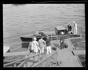 People on a pier by a boat