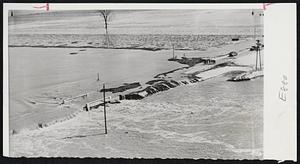 Water Pours Over Road - Muddy waters from the Missouri river pour across U.S. 30 near Blair, Neb., from a break in the dike along the stream. Blair is about 30 miles north of Omaha, Neb. Note persons (right), looking over the site.
