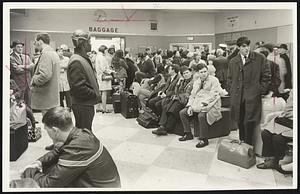 Curtailed bus service left scores of persons awaiting for extended periods in bus terminals yesterday. This view is of the Greyhound bus waiting room.