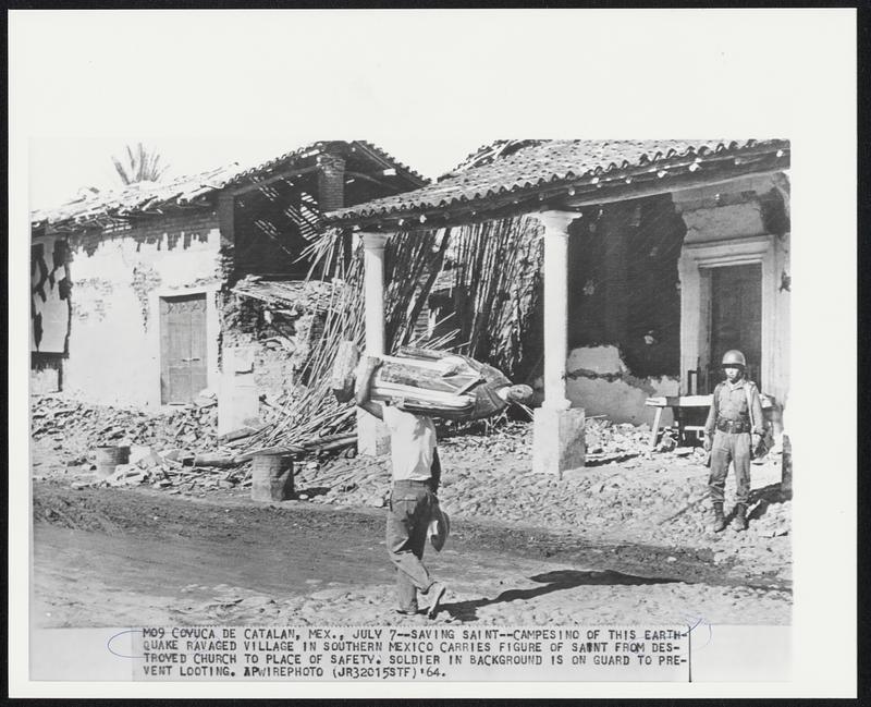 Coyuca de Catalan, Mex. -- Saving Saint -- Campesino of this earthquake ravaged village in Southern Mexico carries figure of saint from destroyed church to place of safety. Soldier in background is on guard to prevent looting.