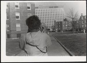 Young person taking photographs in Newtowne Court