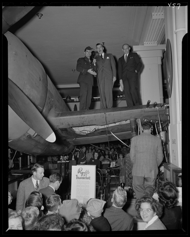 Jack Stanley of WNAC on the wing of a Republic P-47 Thunderbolt at Filene's