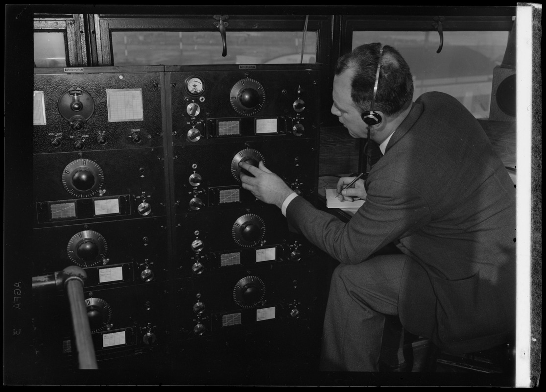 American Airlines traffic control tower. Man turning dial on panel