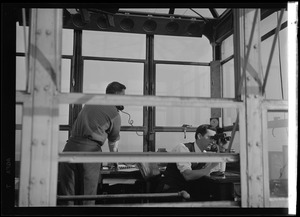 American Airlines traffic control tower. View into tower from outside, two men inside