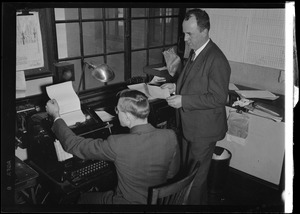 American Airlines traffic control tower. Two men at examining teletype output