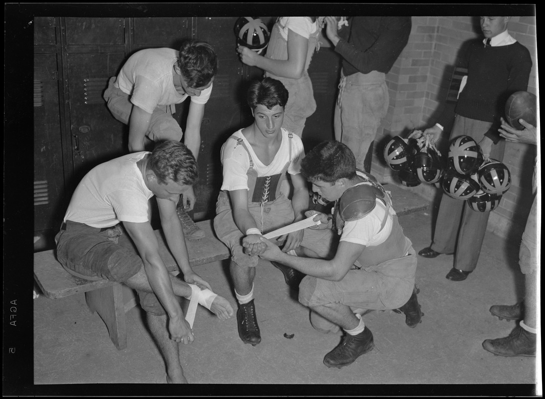 Boston English football. Players tape up joints in locker room