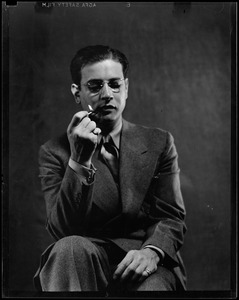 Portrait of a seated man lighting a pipe