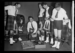 Musicians from the Scottish Highlanders Pipe Band getting dressed