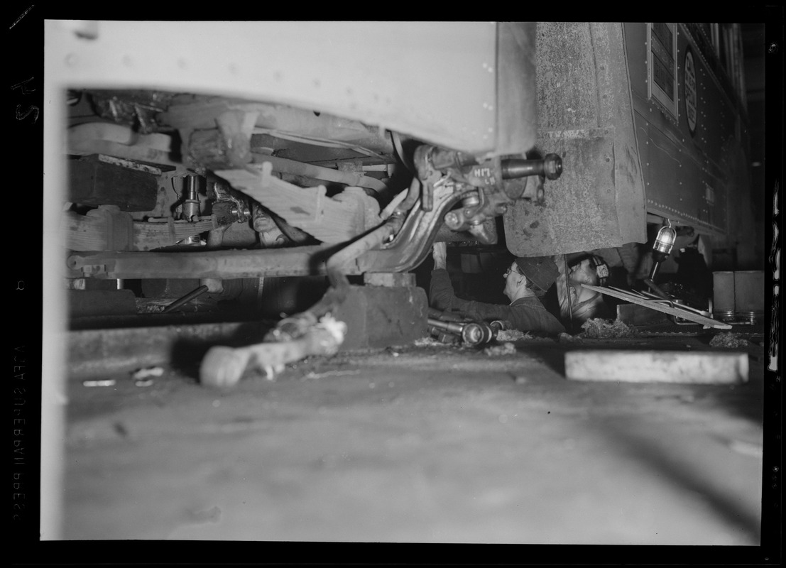 Men working on underside of a bus