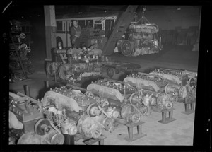 Row of engines and engine on a hoist in bus garage
