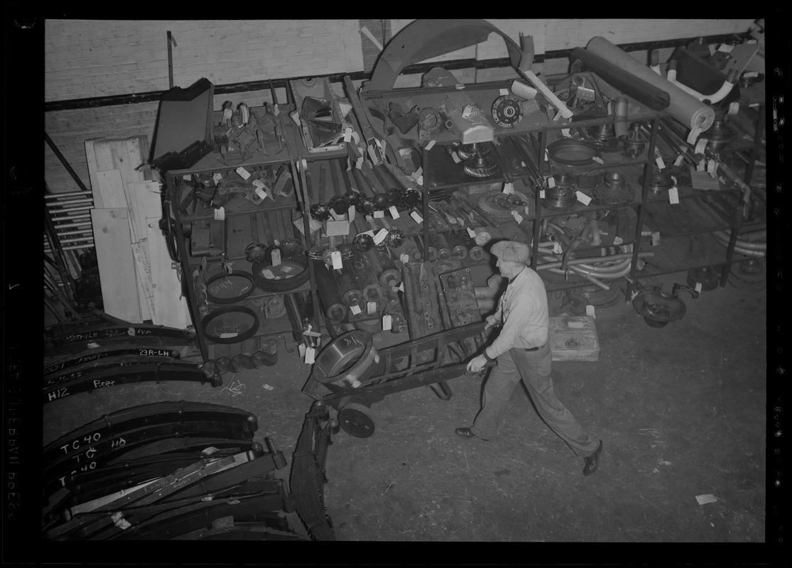 man-pushing-a-hand-truck-through-garage-digital-commonwealth