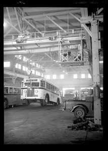 Bus in a garage lifted by a hoist