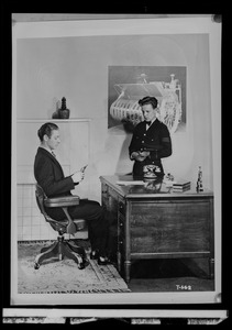 Do/More Chairs advertisement, man seated in chair with a man standing next to a desk