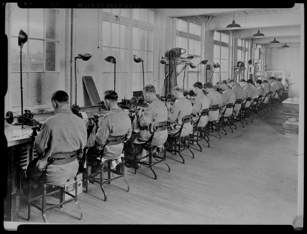 Do/More Chairs advertisement, row of seated men in a factory
