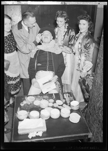 International Institute Costume Ball, man having makeup applied to face