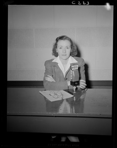 Portrait of a woman sitting at WEEI microphone