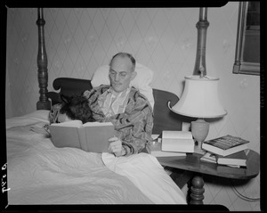 Cedric Foster reading in bed with dog