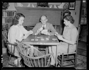 Cedric Foster playing cards with wife and daughter