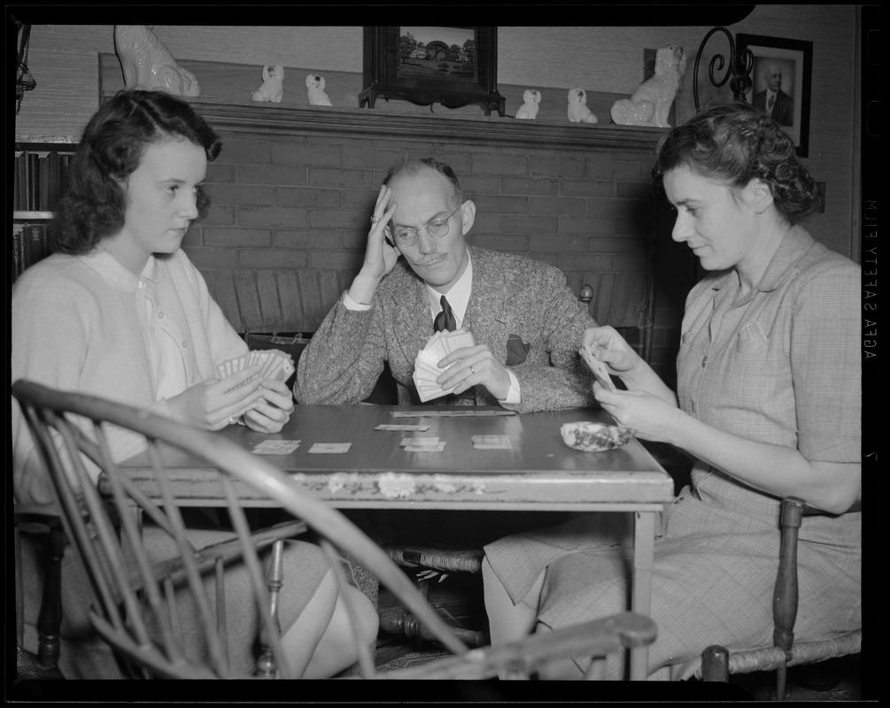 Cedric Foster playing cards with wife and daughter