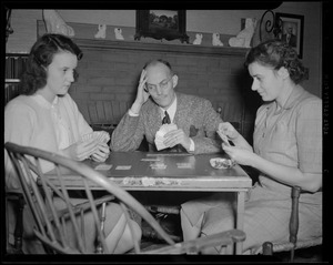 Cedric Foster playing cards with wife and daughter