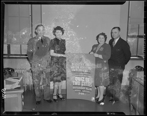 Registry of Motor Vehicles employees stand with a sign promoting Quiz of Two Cities