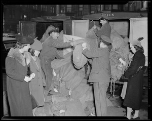 Postal service employees moving bags of letters