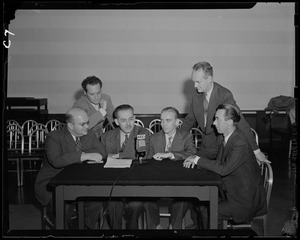 Men sitting around microphone