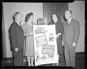 Four people stand with sign promoting Quiz of Two Cities