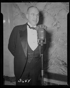 Man at microphone at the N. E. Mutual Concert