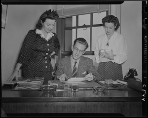 Two women and a man at a desk