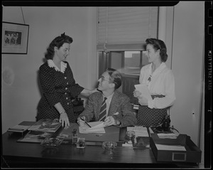 Two women and a man at a desk