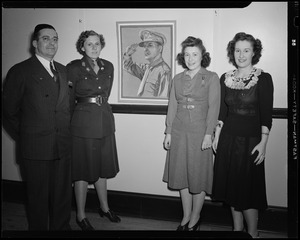 Three women and a man in front of photograph