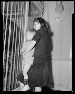 Two children looking in cage
