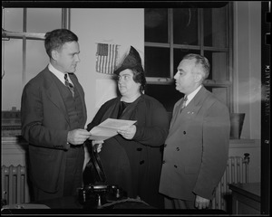 Two men and a woman holding paper